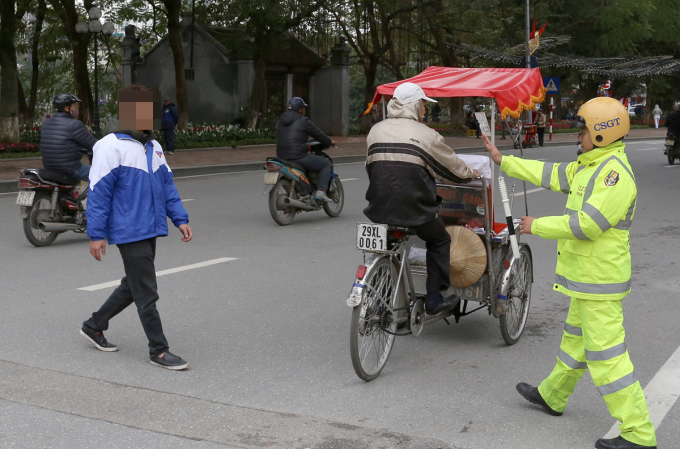 Cảnh sát giao thông xử phạt người đi bộ vi phạm luật giao thông ở Hà Nội. Ảnh: Phương Sơn